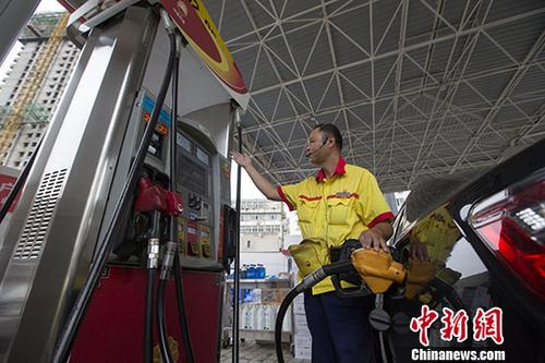 資料圖：一加油站工作人員給車(chē)輛加油。中新社記者張?jiān)茢z